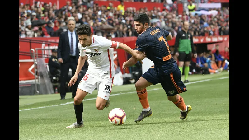 Cầu thủ Valencia vượt qua cầu thủ Sevilla trong trận đấu sôi động.